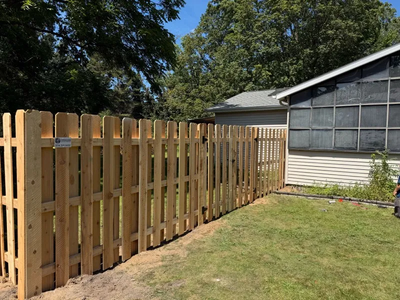 Cedar dog-ear privacy fence with gate beside home, Northern Indiana installation